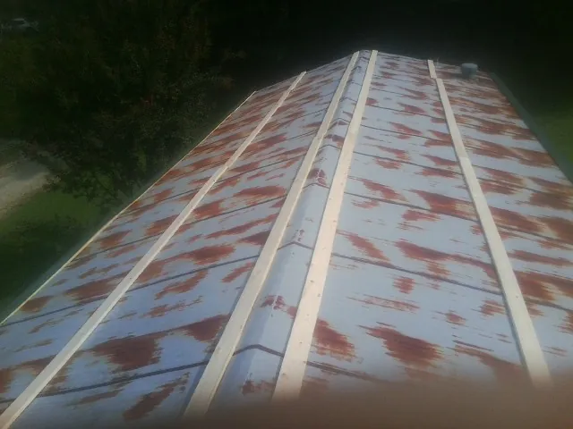 Rusted metal roof panels with new wood purlins before replacement — Storm Damage Roof Repair in Wapello by Roofing Brothers