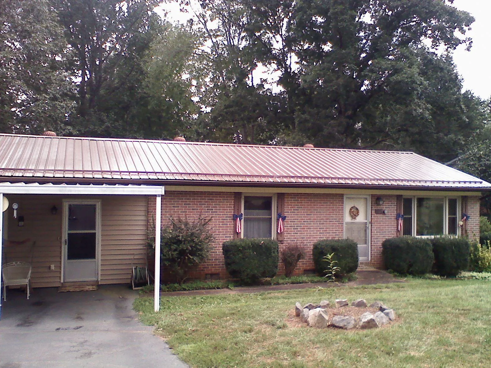 Bronze metal roof and carport on a brick ranch home — Roof Repair work by our crew in Wapello